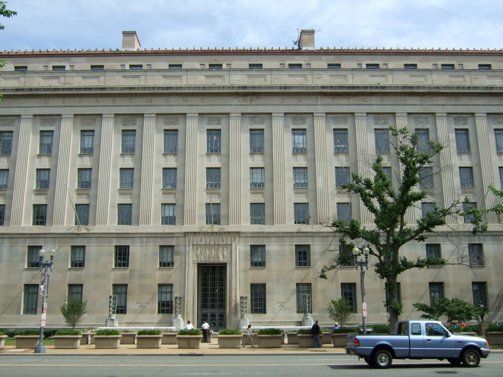 The Robert F. Kennedy Department of Justice Building in Washington, D.C., a gray Art Deco stone structure with carved reliefs above its entrance.