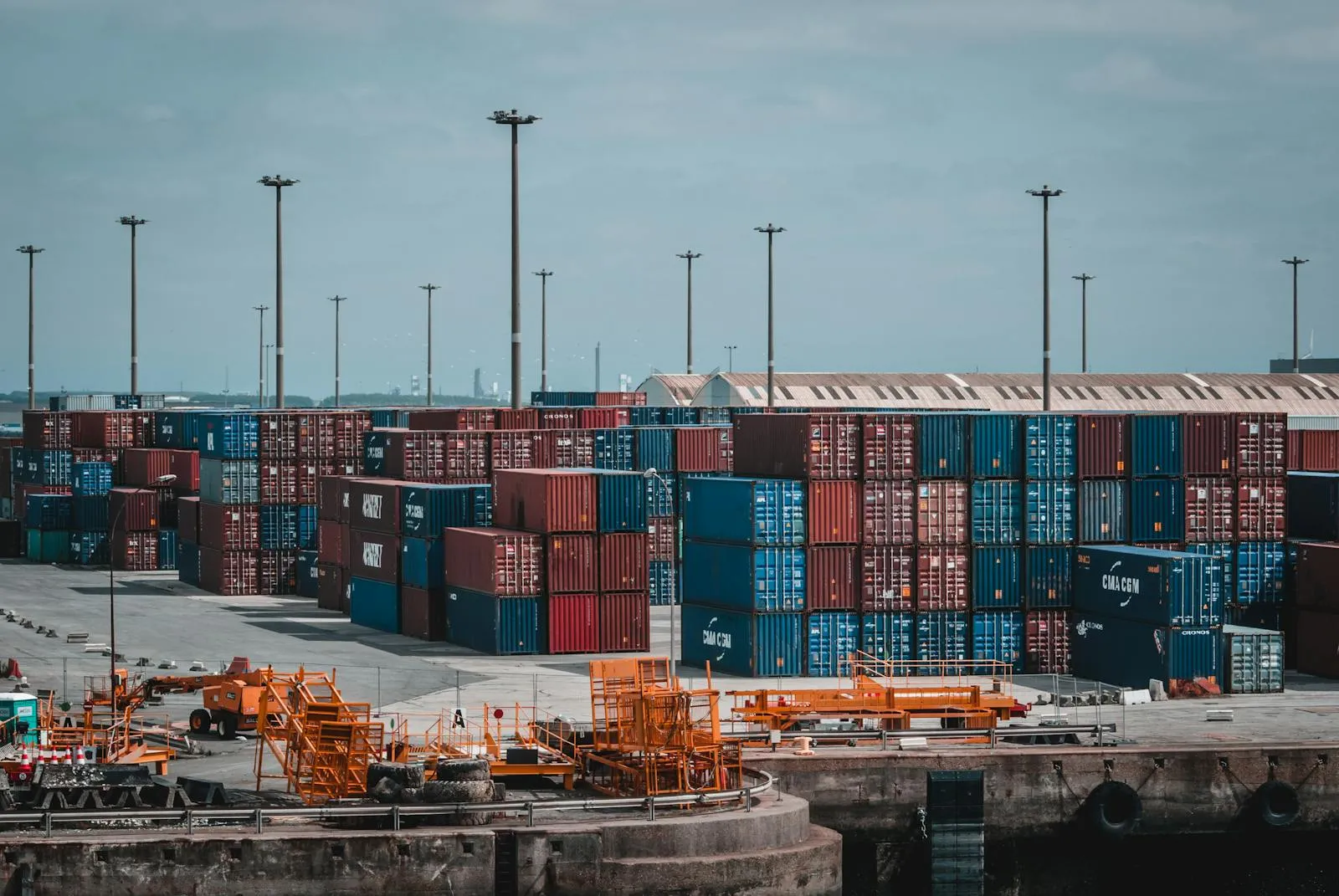 Rows of stacked shipping containers at a port, seen from above.