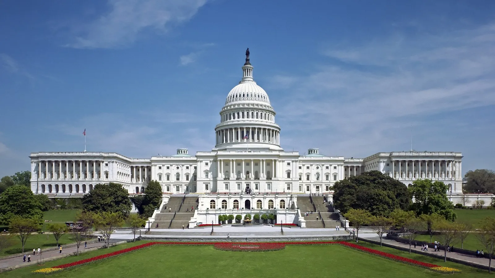 The west front of the United States Capitol building in Washington, with the dome rising above marble columns and steps