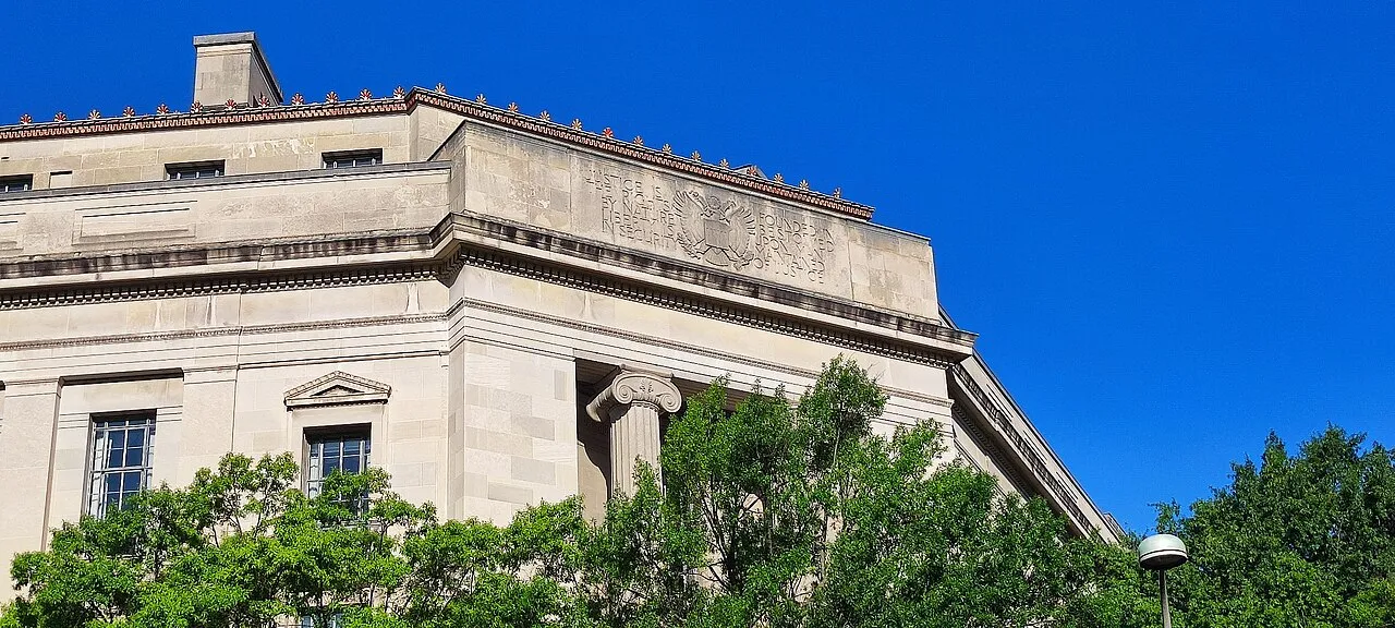 The facade of the Robert F. Kennedy Department of Justice Building in Washington, with a carved inscription about justice above the entrance.