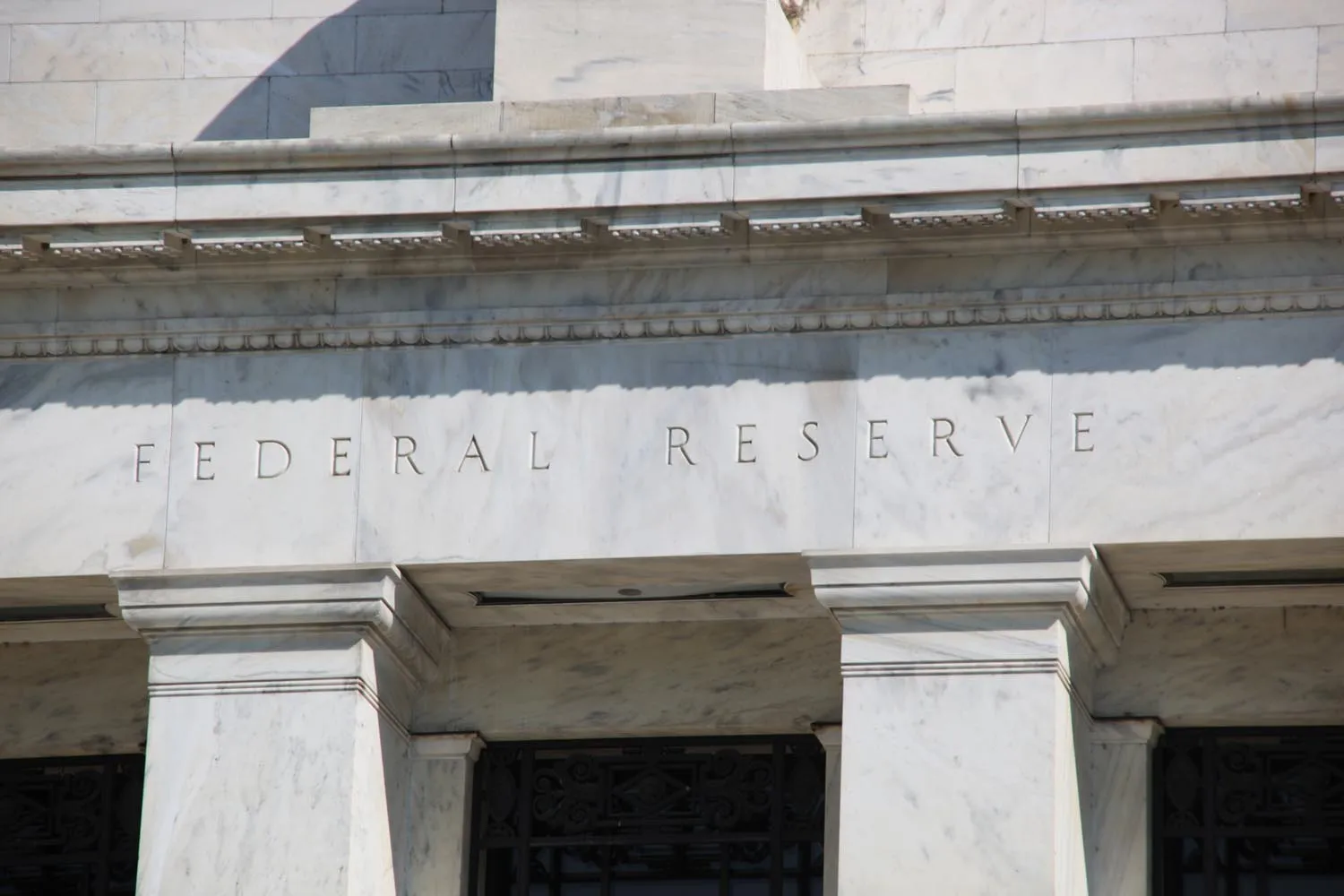 A carved stone entablature reading 'Federal Reserve System' above the entrance of the central bank's Washington headquarters.