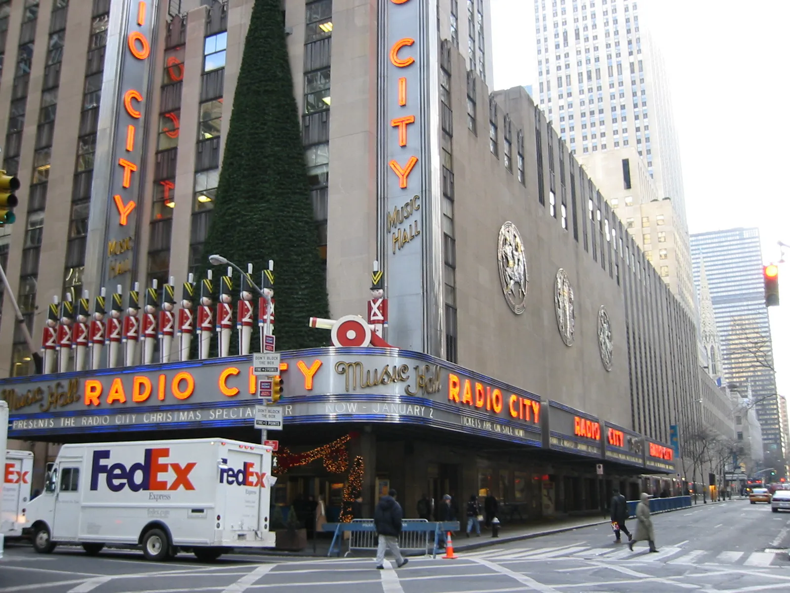 The Radio City Music Hall building on a Manhattan corner with its illuminated neon marquee.