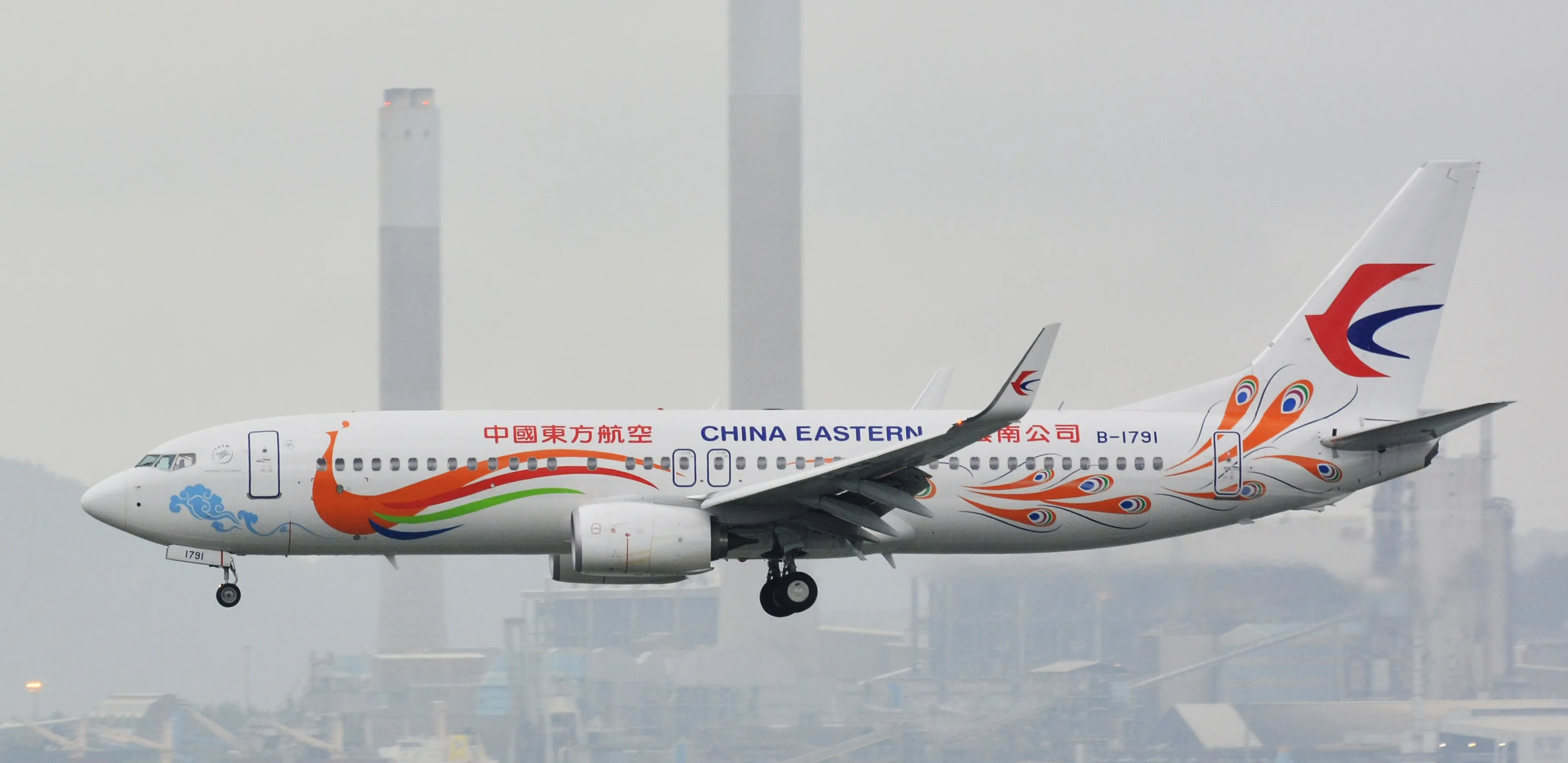 A China Eastern Airlines Boeing 737-800 with Orange Yunnan Peacock livery, registration B-1791, parked at Hong Kong International Airport in August 2015