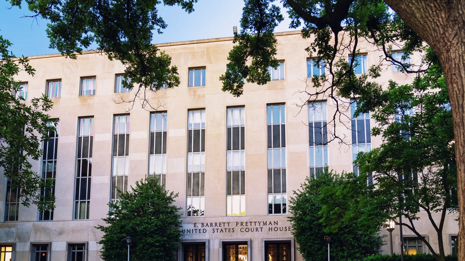 Daytime exterior of the E. Barrett Prettyman United States Courthouse in Washington, D.C., a stone neoclassical federal building.