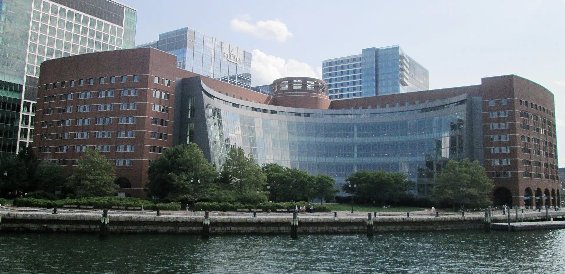 The John Joseph Moakley United States Courthouse on Boston's waterfront, viewed across the harbor under a blue sky.