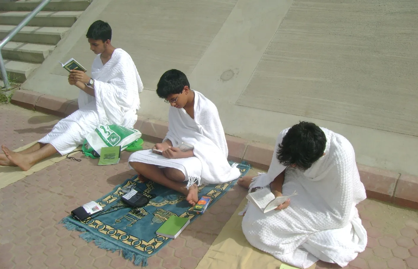 Thousands of white-robed pilgrims filling the dusty Plain of Arafat during Hajj, with tents stretching toward the horizon