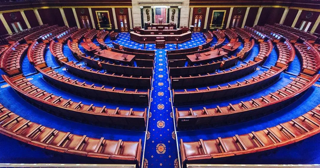 The interior of the United States House of Representatives chamber, showing rows of seats and the raised dais at the front.