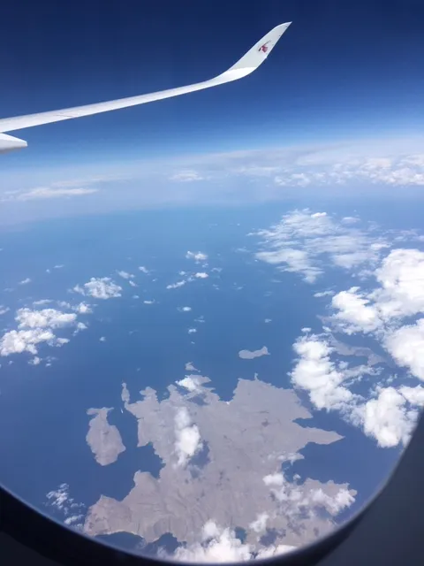 Aerial view from a commercial aircraft at 35,000 feet looking down at the narrow Strait of Hormuz between Iran's coastline and Oman's Musandam Peninsula