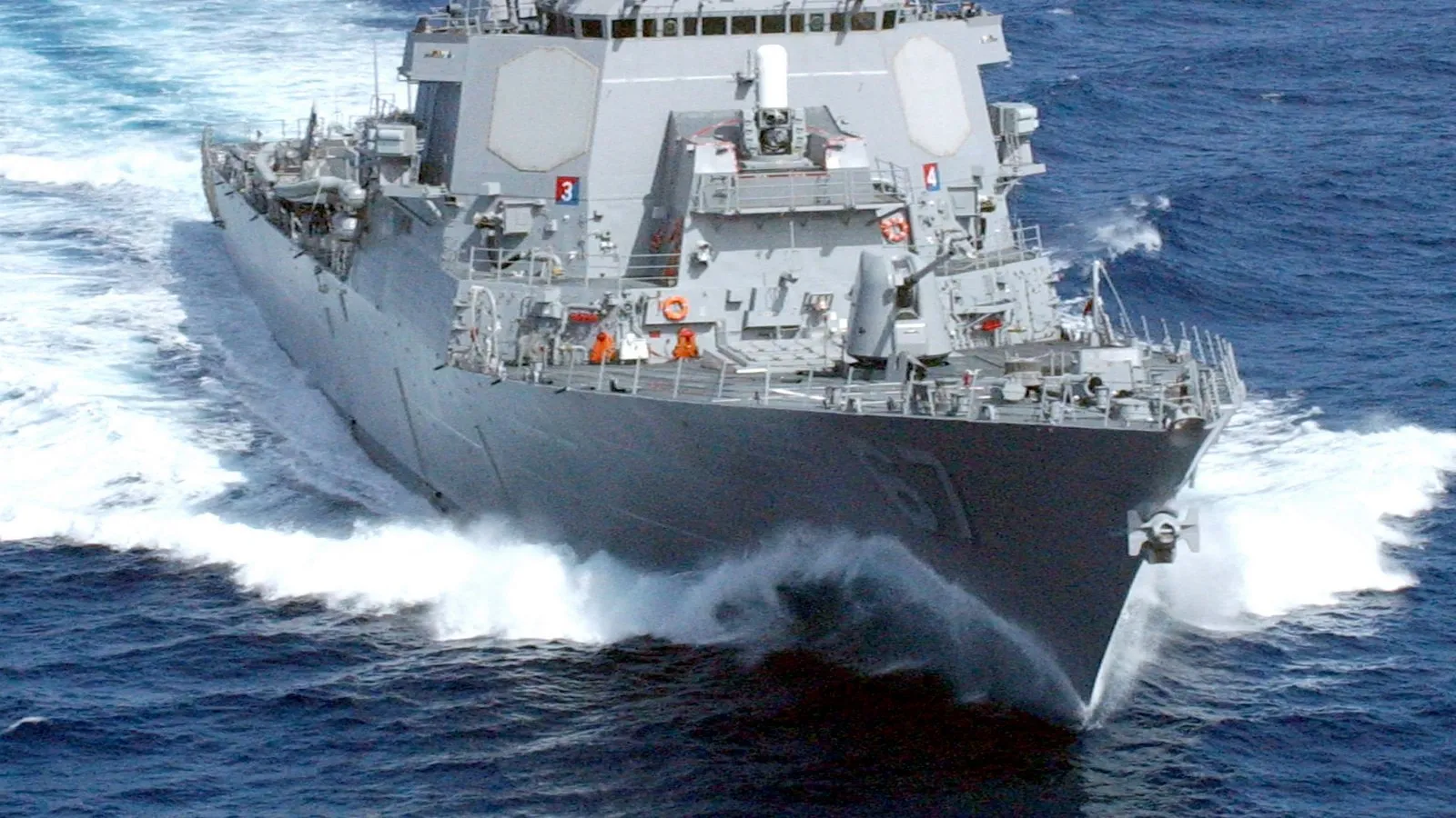 An Arleigh Burke-class U.S. Navy guided-missile destroyer underway at sea, viewed from the front quarter, hull number visible on the bow.