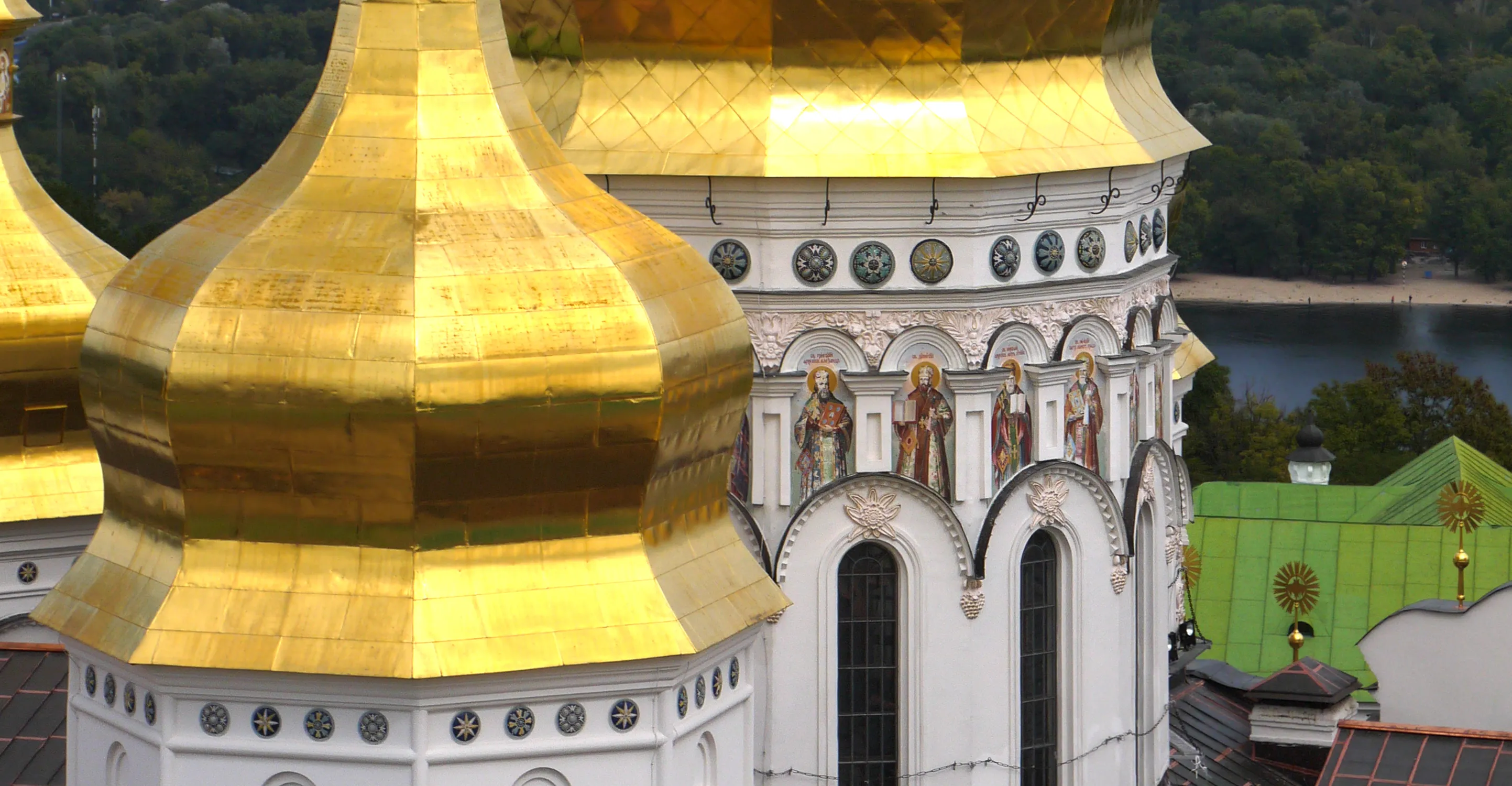 The white-walled, gold-domed Dormition Cathedral of the Kyiv Pechersk Lavra monastery standing under a bright sky