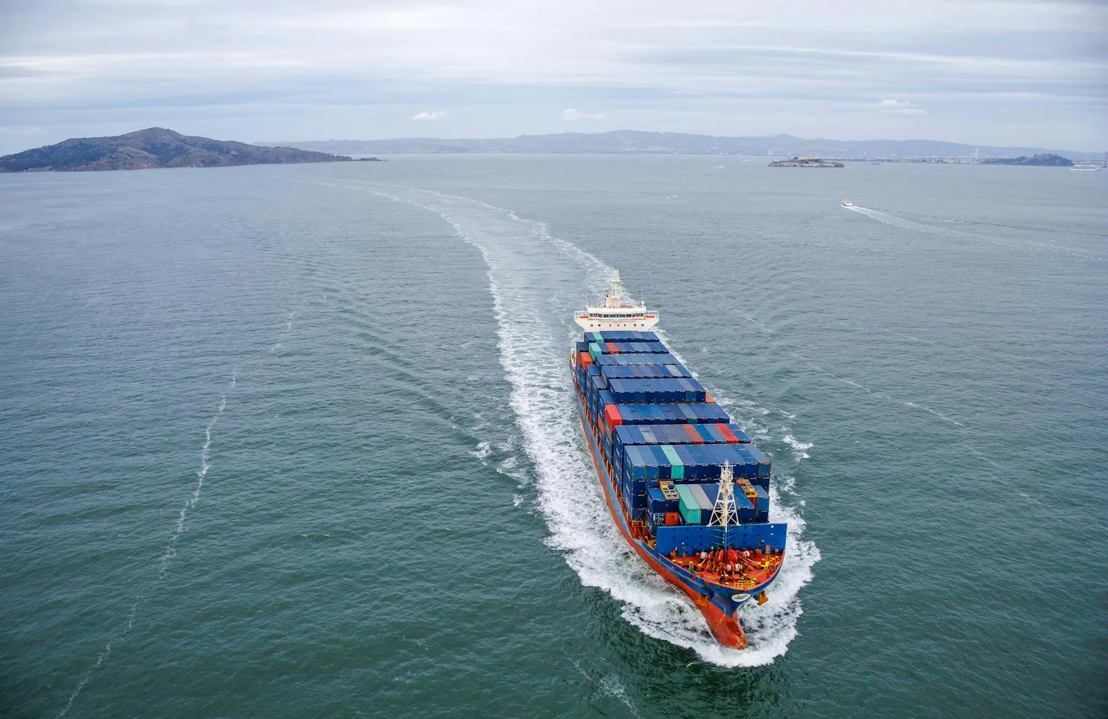 Aerial view of a cargo ship underway on open ocean, seen from directly above