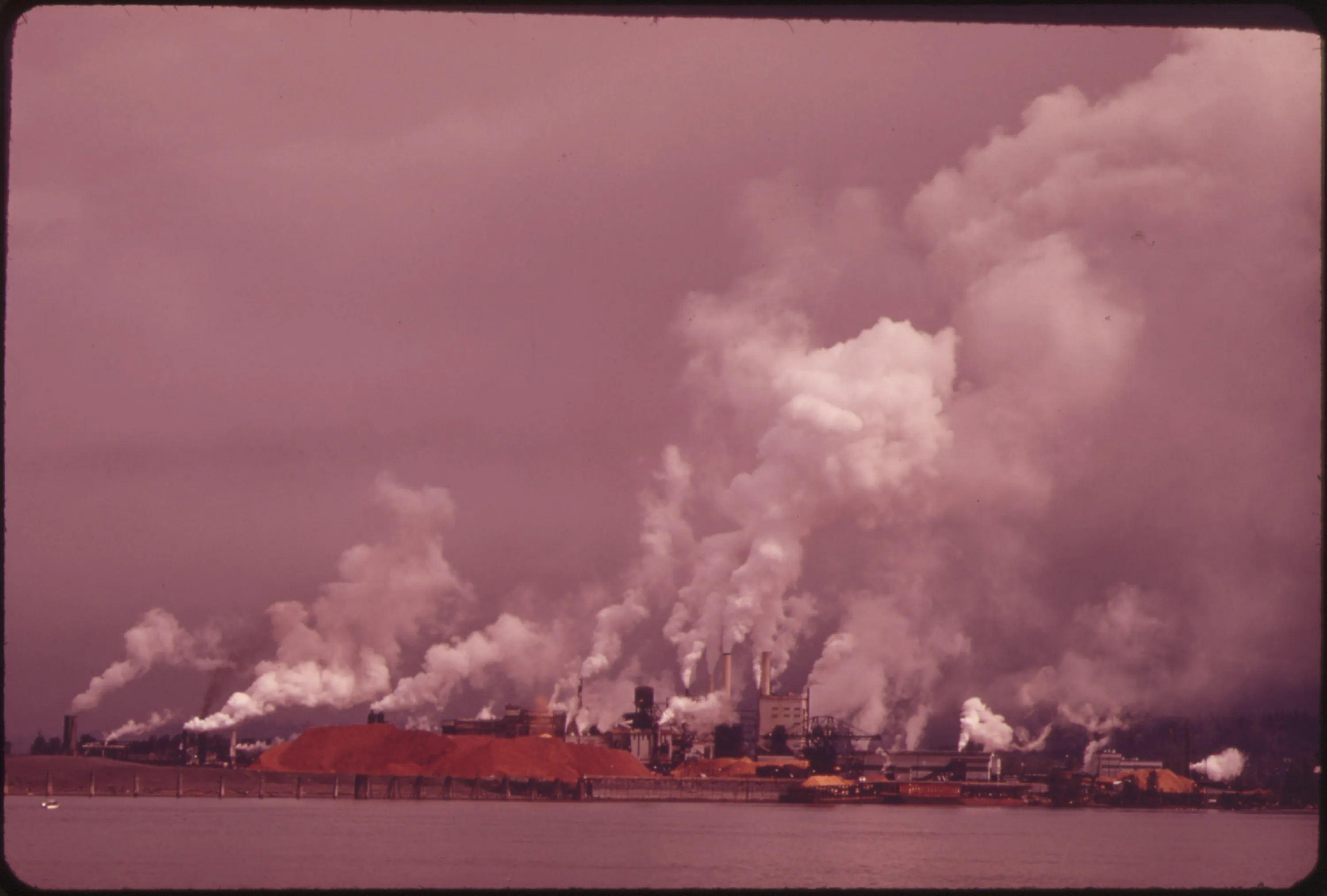 Aerial view of industrial paper mills and an aluminum plant along the Columbia River in Longview, Washington, with smoke rising from stacks