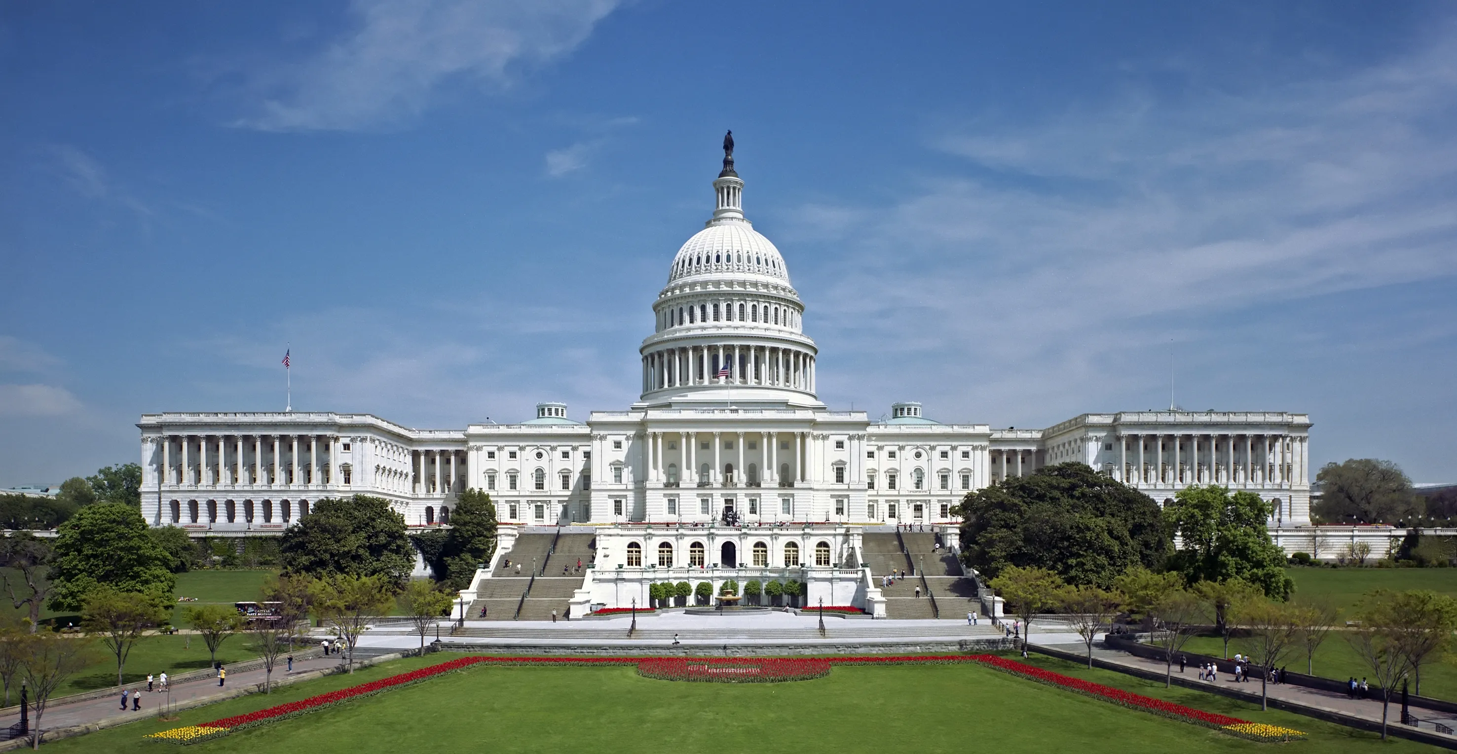 The west front of the United States Capitol building in Washington, D.C., with the dome rising against a clear sky