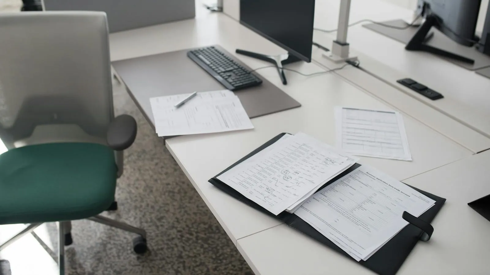 An empty modern office floor with rows of unoccupied desks.