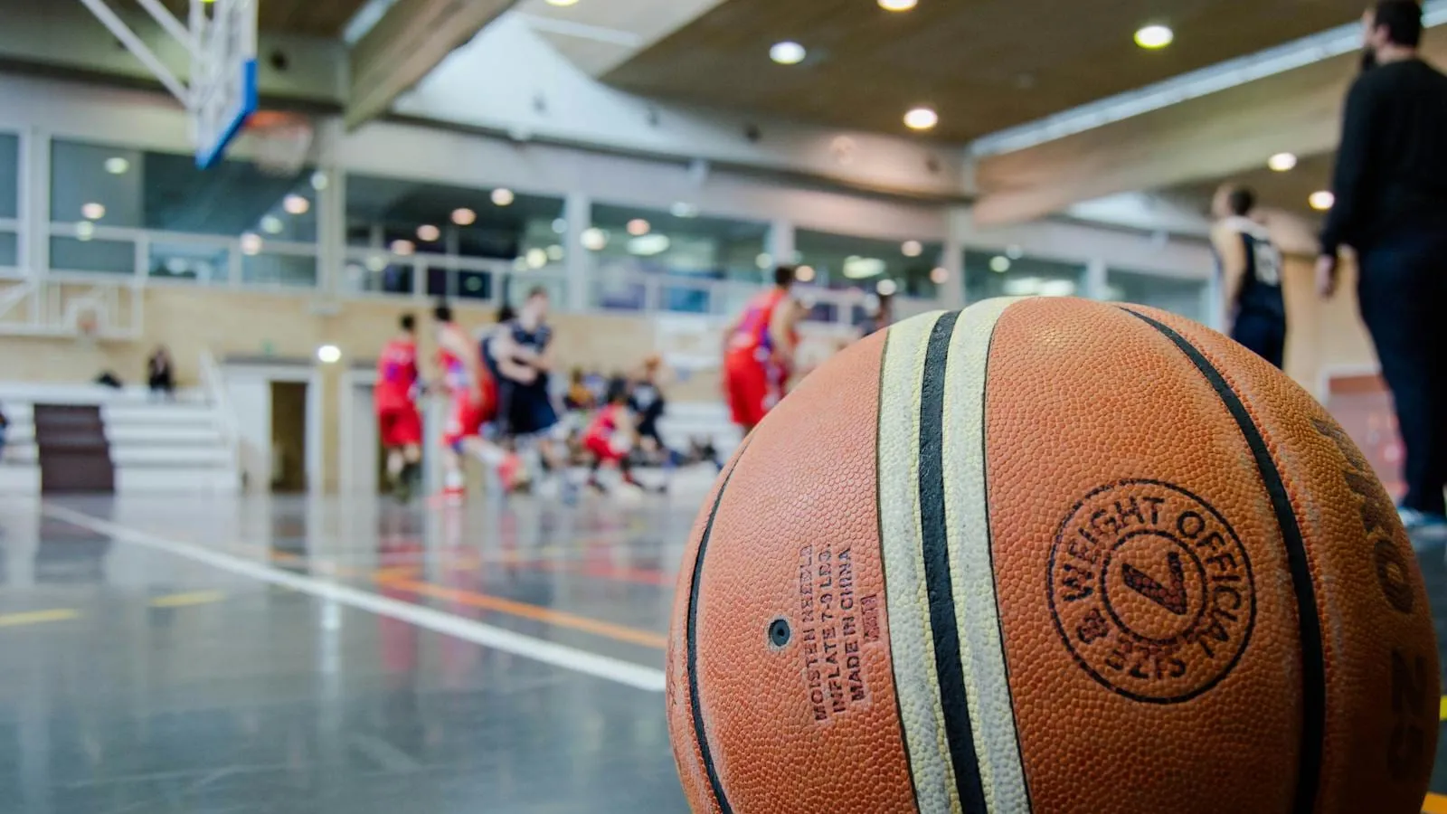 An indoor basketball court viewed from one baseline.