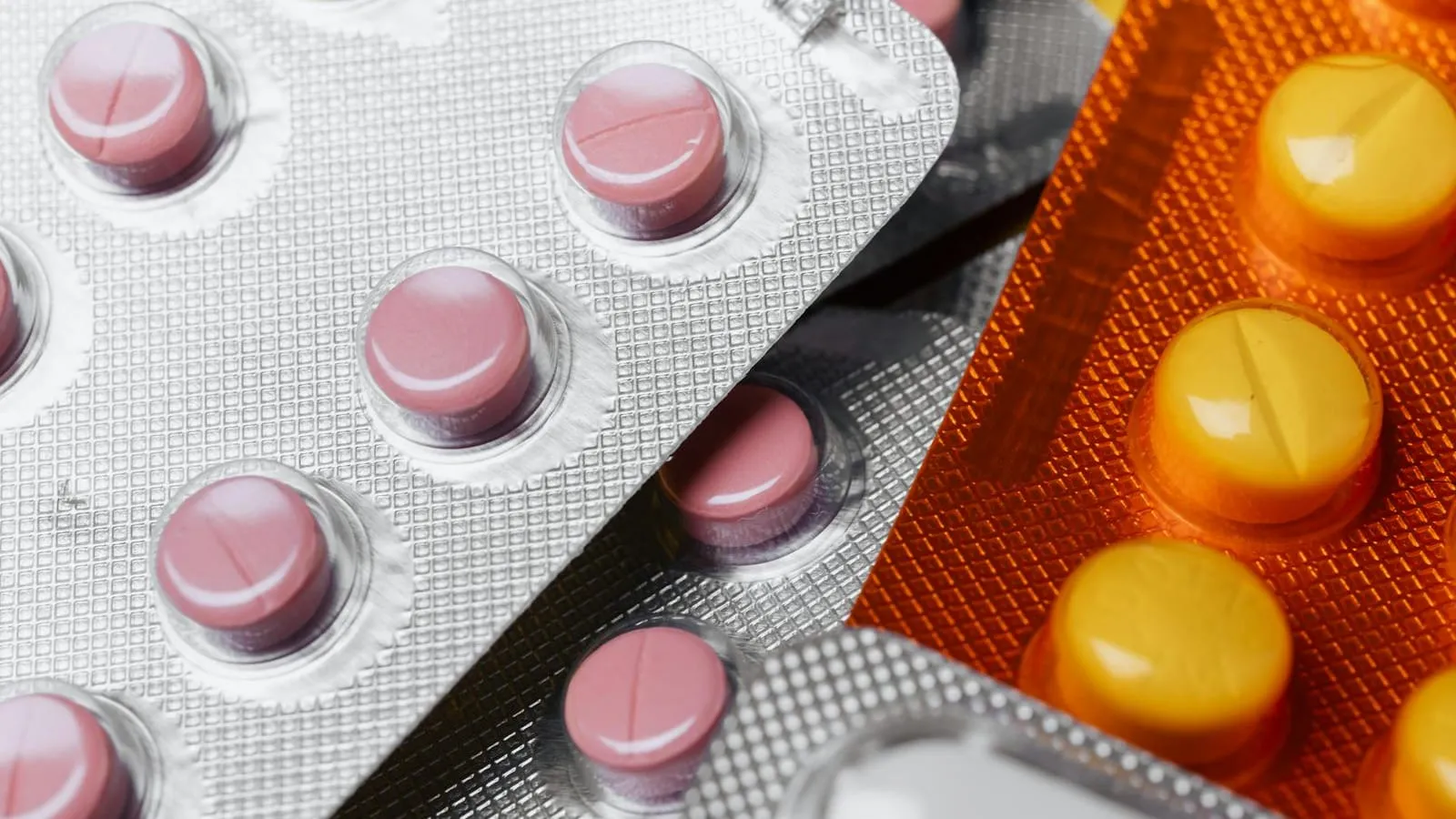 A close-up of pharmaceutical pills and capsules in mixed colors.