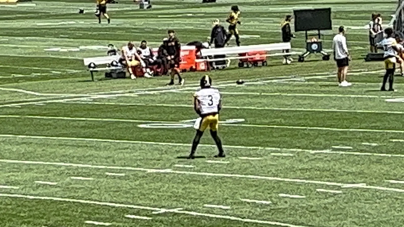 Russell Wilson in a black-and-gold quarterback uniform on the field during a game
