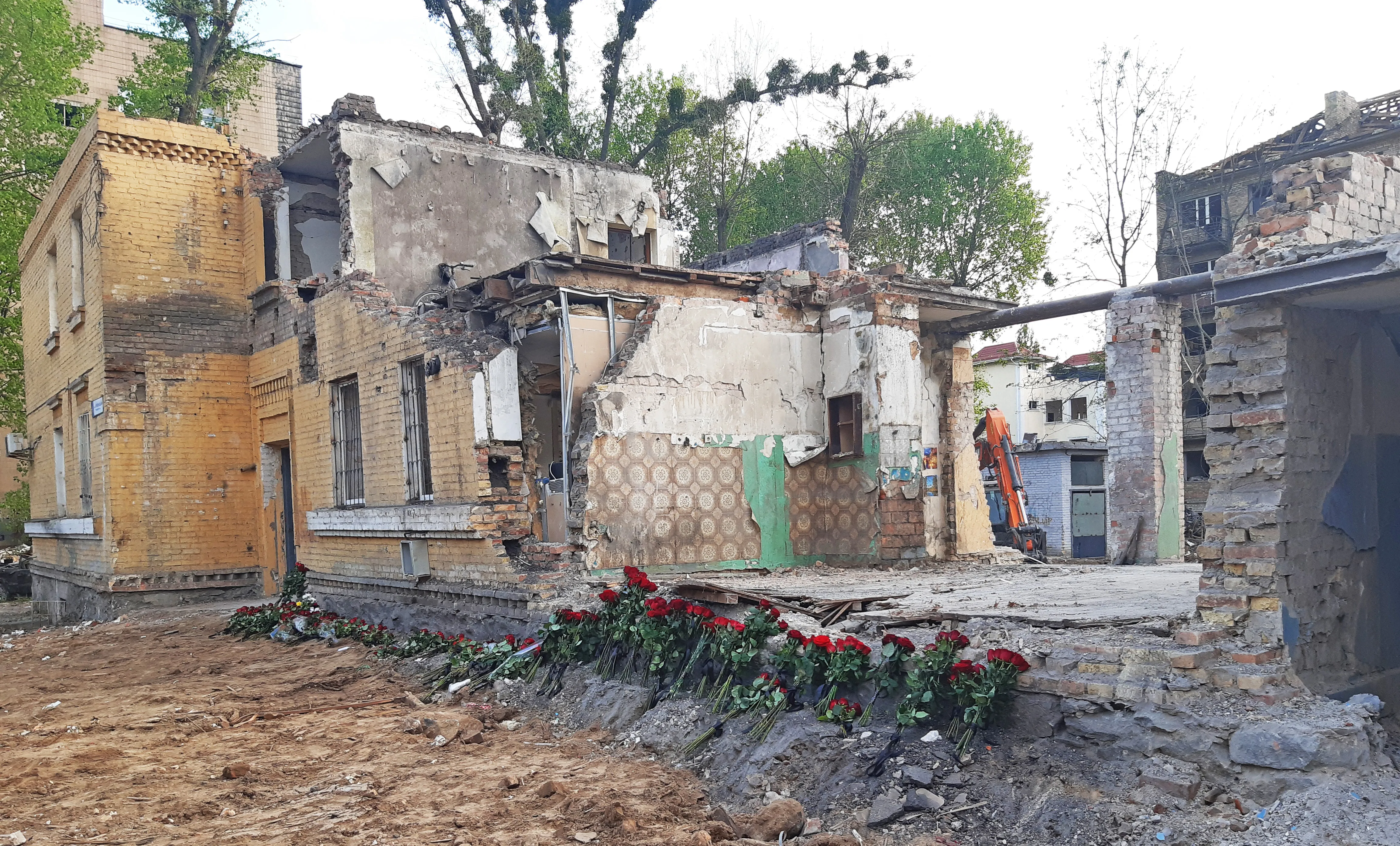 A multi-story residential building in Kyiv with severe blast and fire damage, blown-out windows across multiple floors, and debris on the street below