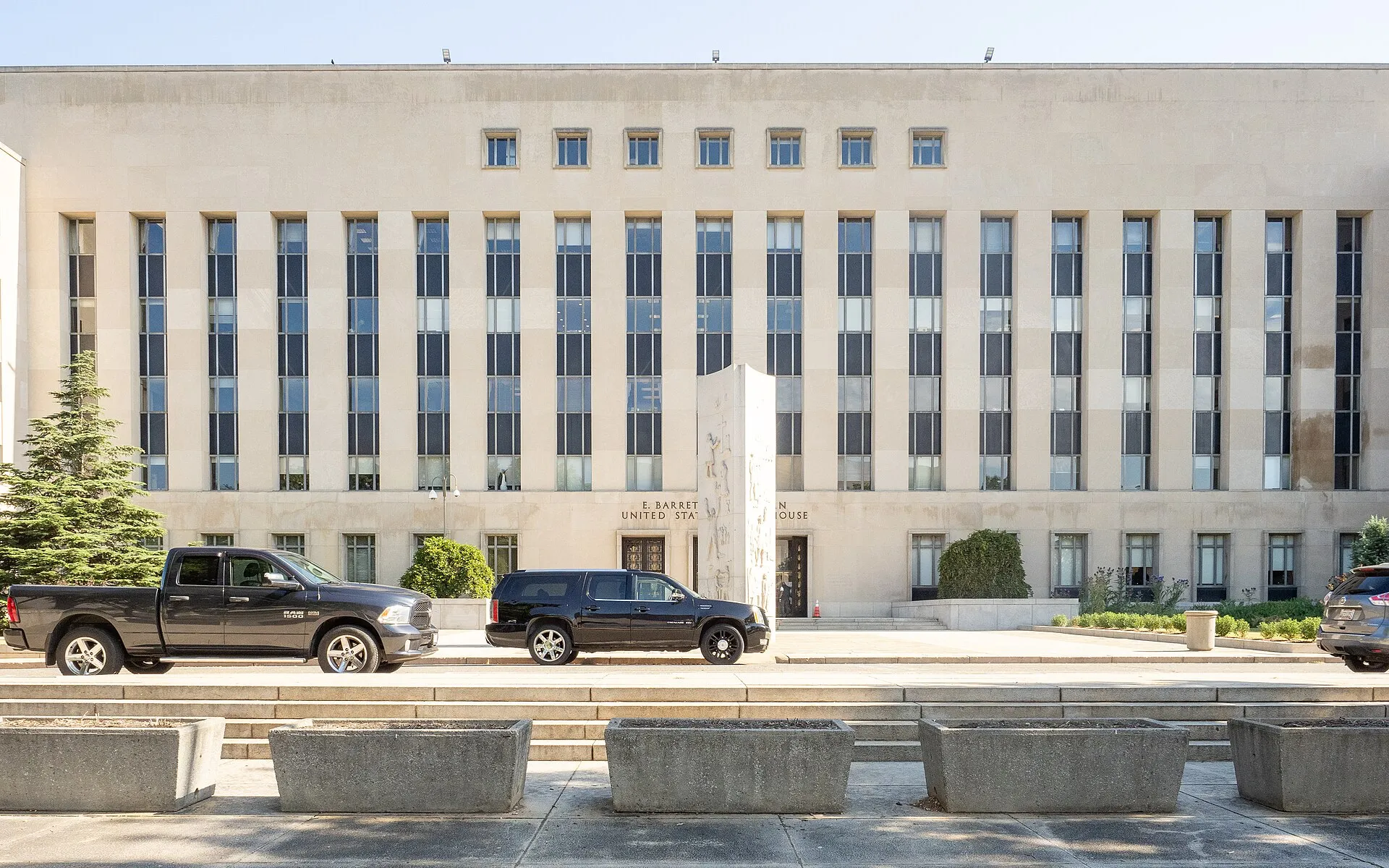 The columned stone facade and entrance of the E. Barrett Prettyman United States Courthouse in Washington, D.C., seen from the plaza.