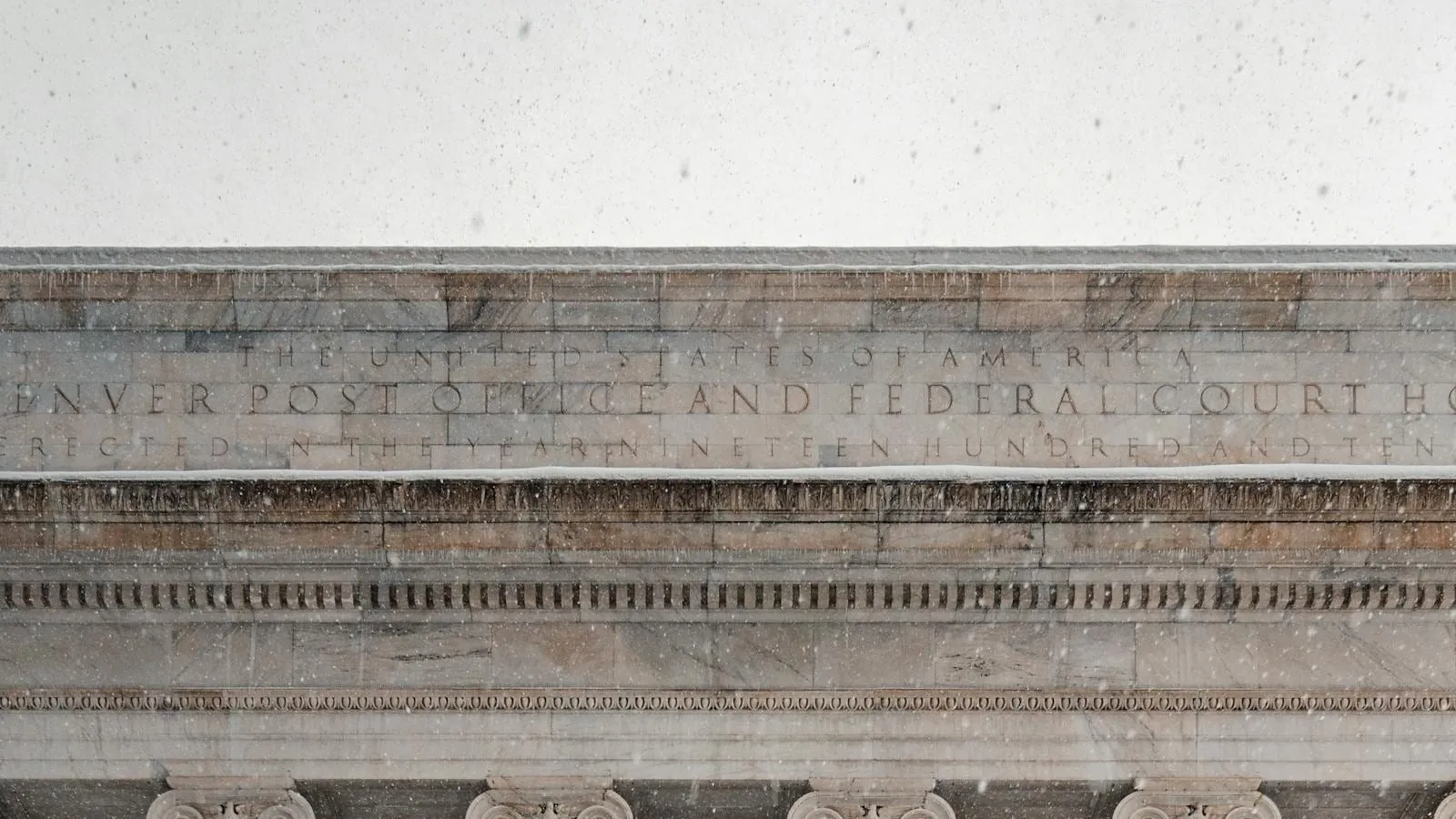 Stone columns of a U.S. federal courthouse, seen at street level.