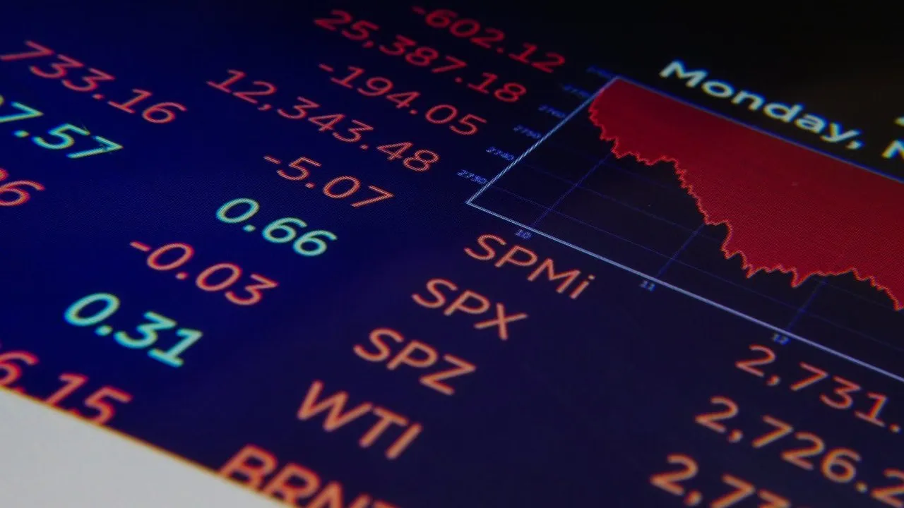 A financial screen showing market indices in red, with negative figures and a downward red chart beside the S&P 500 ticker.