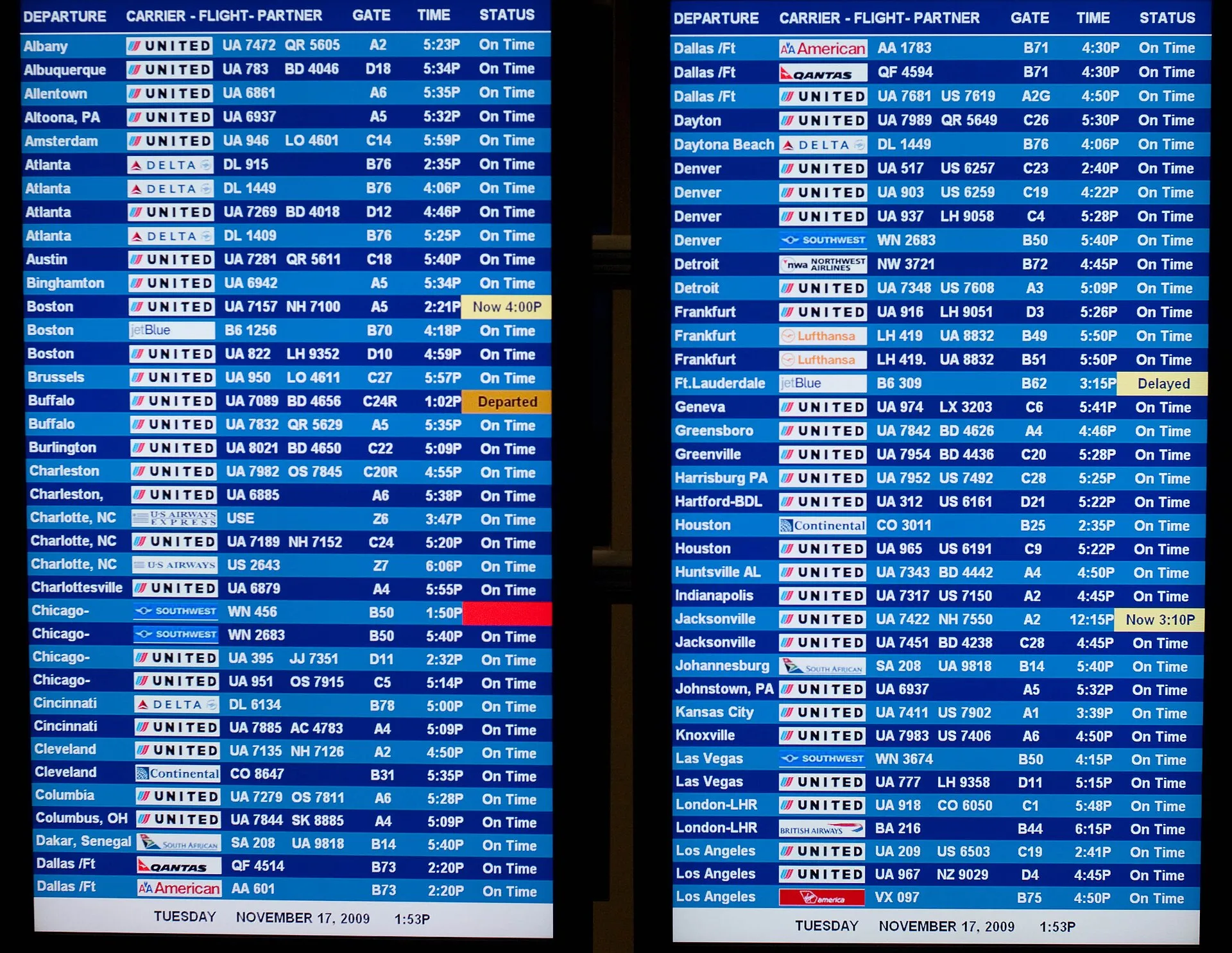 A large flight information board at an airport displaying rows of departure and arrival times.