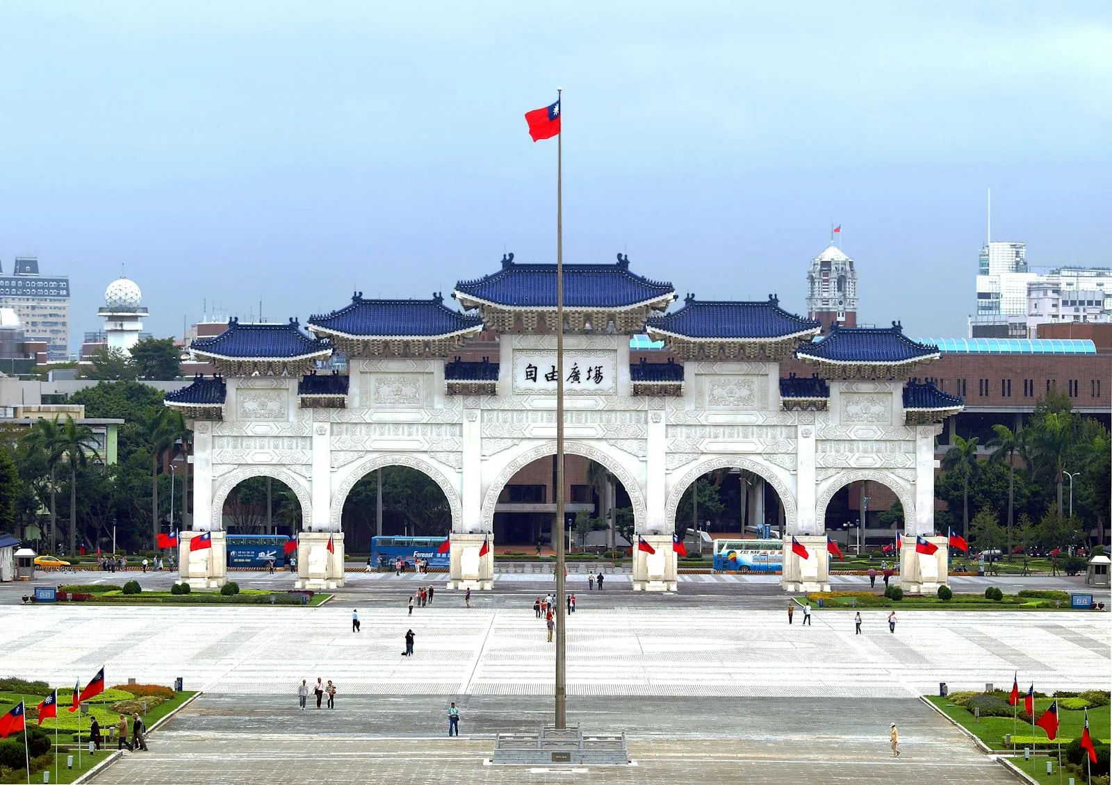 Wide view of Liberty Square in Taipei, Taiwan, with the ceremonial arch gate and traditional Chinese-style blue-roofed architecture under a partly cloudy sky
