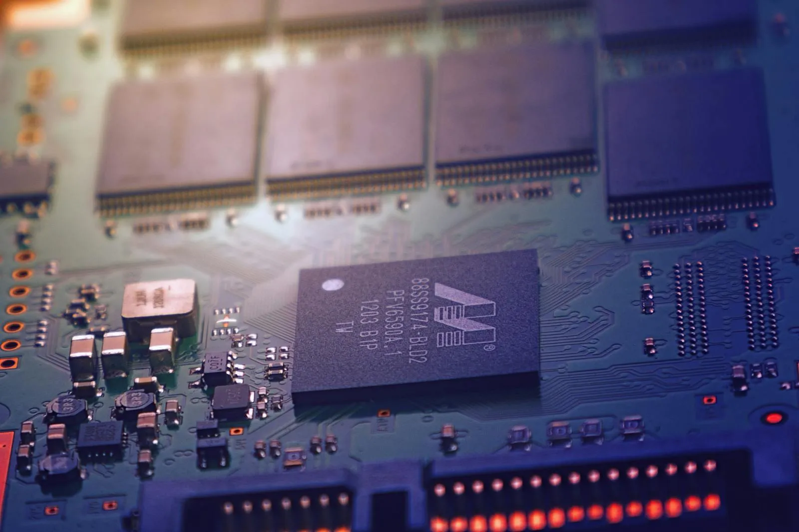 Close-up of a blue-tinted circuit board with a microprocessor chip at center and rows of memory modules in the background